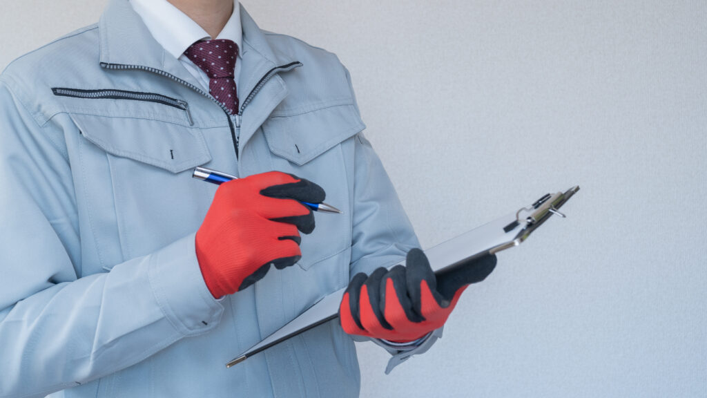 バインダーを持って点検する男性