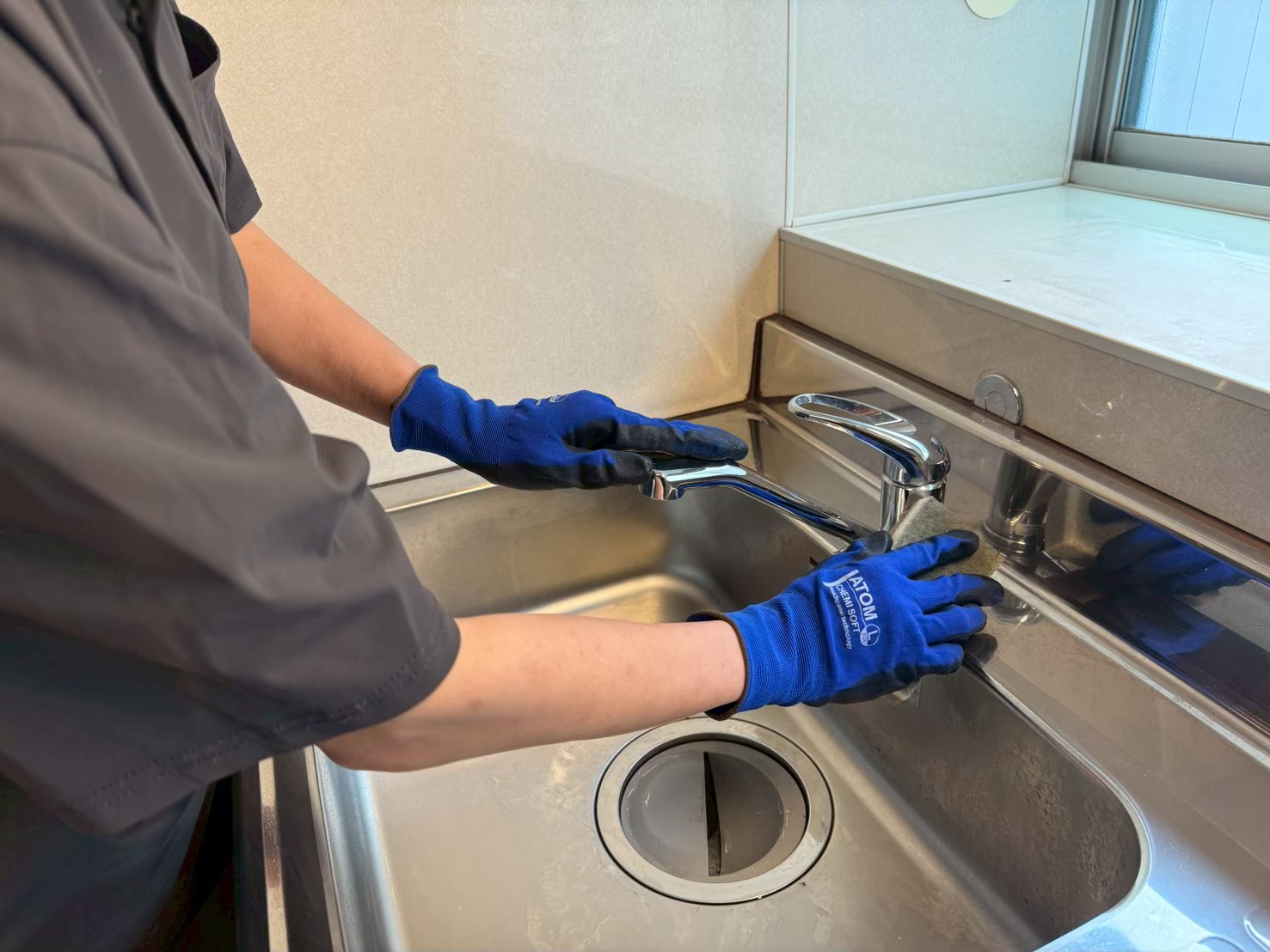 キッチンの蛇口を掃除する様子