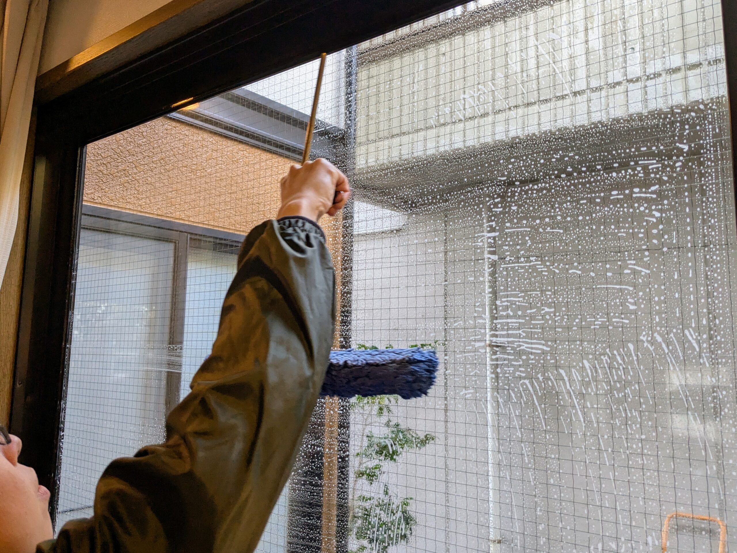 スクイジーで窓の水を切る様子