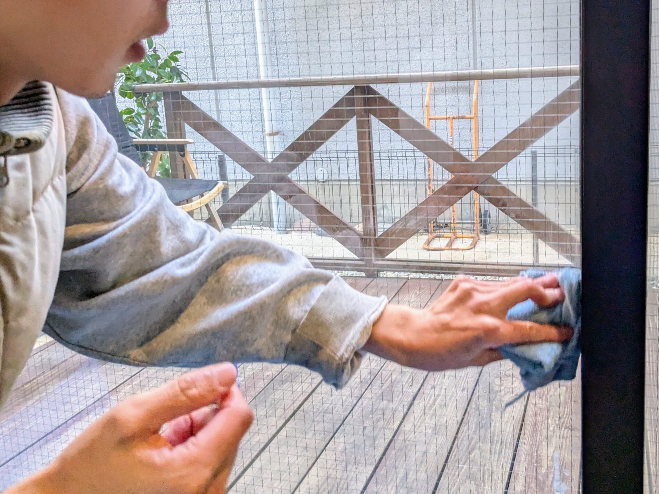 窓のフチをぞうきんで拭く様子